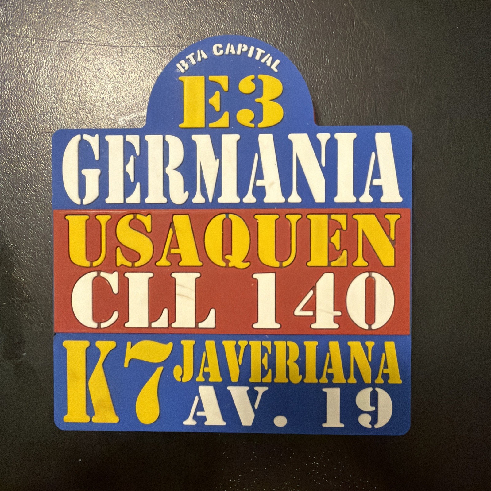 souvenir pin or coaster designed to look like a vintage Bogotá bus route sign,