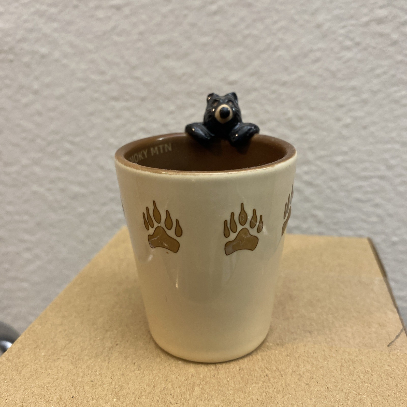 Yellowstone National Park black bear on rim with paw prints green ceramic shot