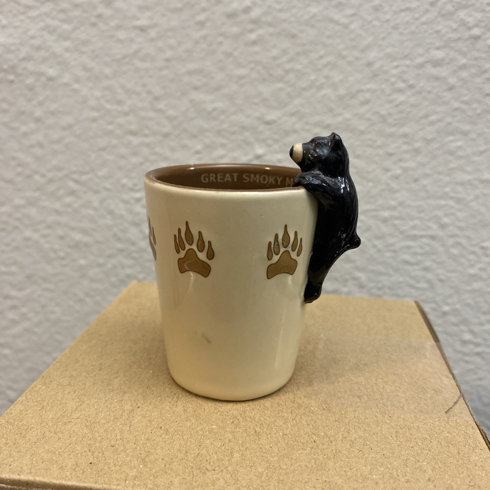 Yellowstone National Park black bear on rim with paw prints green ceramic shot